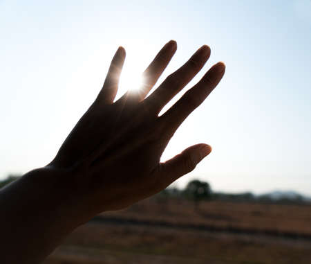 Silhouette of hand with sunsetの写真素材