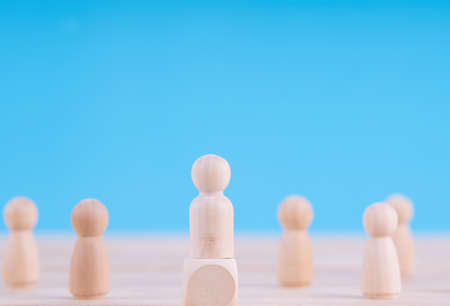 Wooden figures in photo of people.  Team and leader concept