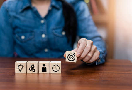 Businessman hand arranging wood block with icon business strategy