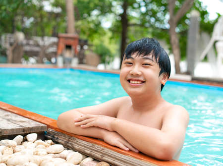 Teenage smile and swimming in the  pool on summer holidayの写真素材