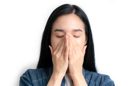 Asia woman having headache and feeling unwell and touching her faces on white backgroundの写真素材