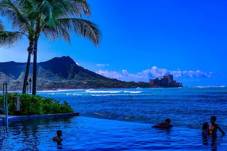 Waikiki , Oahu,  Hawaii, USA - September 4, 2015:  Tourists enjoy a dip in the pool while overlooking Waikiki Beach and Diamond Head crater.のeditorial素材
