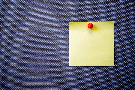 yellow reminder sticky note on grey bankground, empty space for text