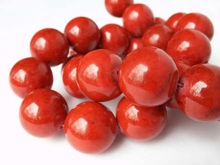 Glossy red coral beads knot on white backgroundの写真素材