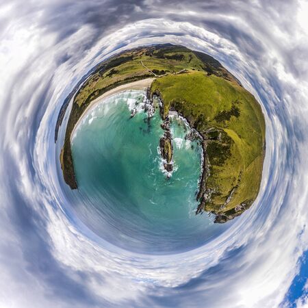 Aerial tiny planet of the green cliffs and blue ocean with clouds on a sky
