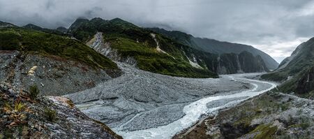 Small river coming from the mountains during cloudy dayの写真素材