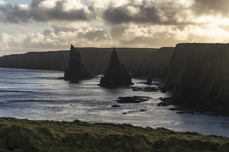 High cliffs on a shore of the sea with cloudy skyの写真素材