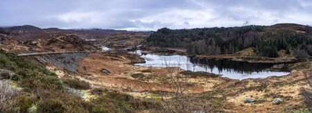 Panoramic view on a small lake with forest in a highlandsの写真素材