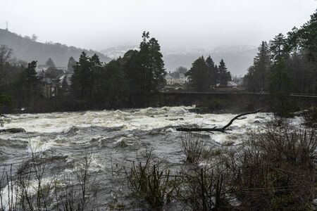Flooded dangerous river during rainy and cloudy days