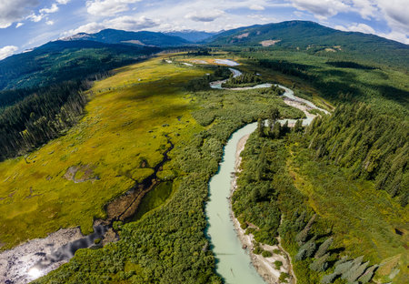 River in a mountains and green meadows aerial viewの写真素材