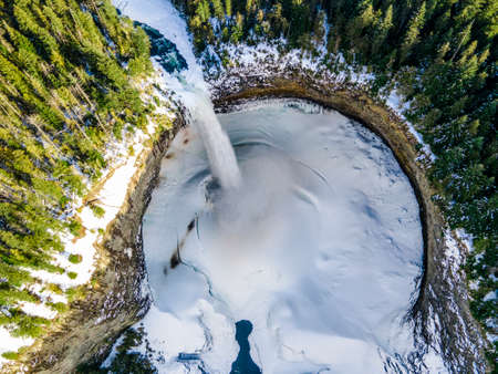 Waterfall with cliffs and ice crater from above view