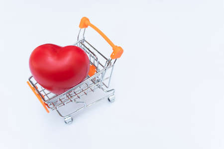 The red heart is in the shopping cart. Design guidelines are Love in simple online shopping Just choose to enter the basket White backgroundの写真素材