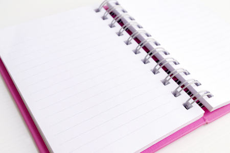 Opened pink note book on white background