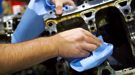 Close up video of male hand wipes the engine spare before installing into the motor. Footage. Auto...