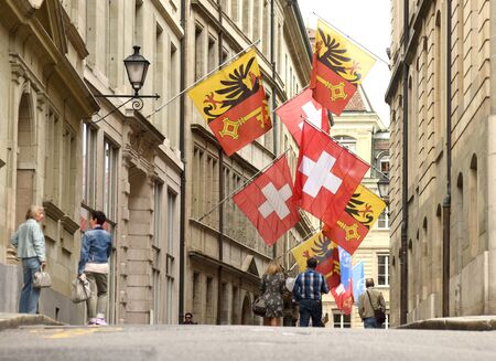 Geneva, Switzerland - June 05, 2017: Swiss Flag and Flag of Geneva on the facade building in Geneva,...
