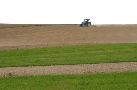 tractor at work cultivating a field in spring, farmland, plowed field,の写真素材