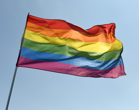 rainbow flag on blue skyの写真素材