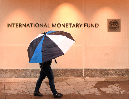 Washington, DC - June 04, 2018: Pedestrian with an umbrella near International Monetary Fund, IMF Headquarters 2 Building (HQ2) in DC.のeditorial素材