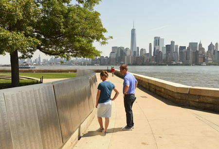 New York, USA - June 09, 2018: People look on the American Immigrant Wall of Honor is located at the Ellis Island National Museum.のeditorial素材