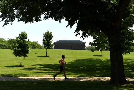 Washington, DC - June 01, 2018: Runner man and the National Museum of African American History and Culture in Washington, DC.のeditorial素材