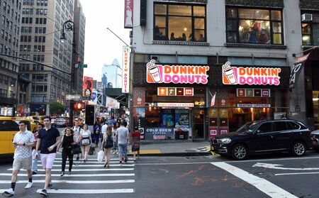 New York, USA - May 27, 2018: People on the street near the Dunkin' Donuts in New York.のeditorial素材