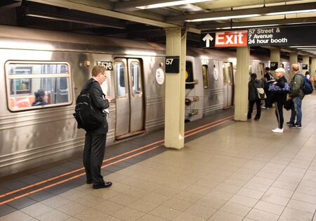 New York, USA - June 8, 2018: People on subway platform waiting for the train in New York.
