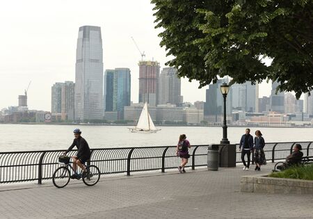 New York, USA - May 28, 2018: People in the Battery Park in Manhattan and Jersey City at the background.のeditorial素材
