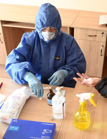 Lviv, Ukraine - March 31, 2020: A medical worker makes a rapid test for coronavirus COVID-19 of a...