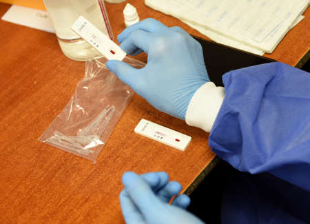 Lviv, Ukraine - March 31, 2020: A medical worker makes a rapid test for coronavirus COVID-19 of a...