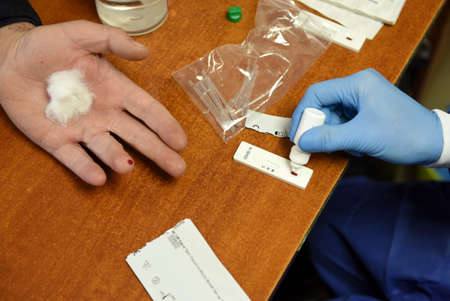 Lviv, Ukraine - March 31, 2020: A medical worker makes a rapid test for coronavirus COVID-19 of a...