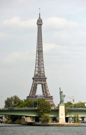 Paris, France - August 28, 2019: Statue of Liberty in Paris and Eiffel Tower at the background.のeditorial素材