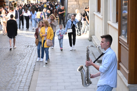 Lviv, Ukraine - April 23, 2023: A street musician performs in center the city of Lviv.
