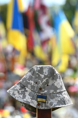Soldier's hat on the grave at Military cemetery of Ukrainian soldiers killed during combat with Russian troopsの写真素材