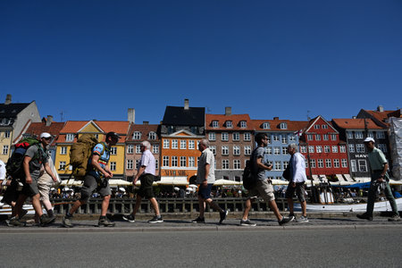 Copenhagen, Denmark - August 1, 2024: People in New Harbour (Nyhavn) is a 17th-century waterfront,...