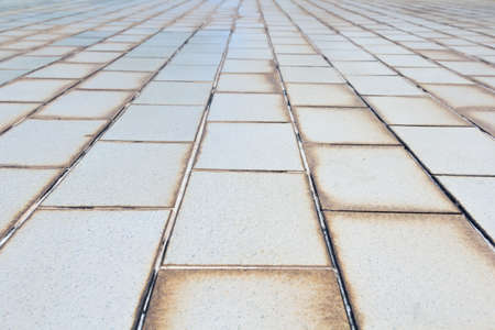 Small-scale background texture of old white tile pavementの写真素材