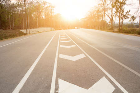 road up hill to the mountain top at at sunny sunset.の写真素材