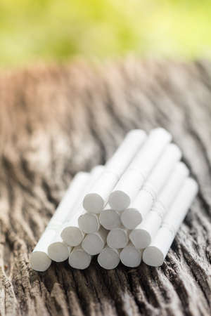 cigarette on a wooden table.ligth and color effect.の写真素材