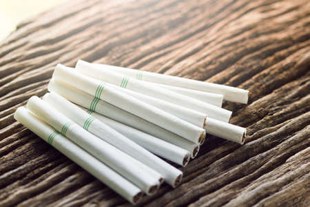 cigarette on a wooden table.ligth and color effect.の写真素材