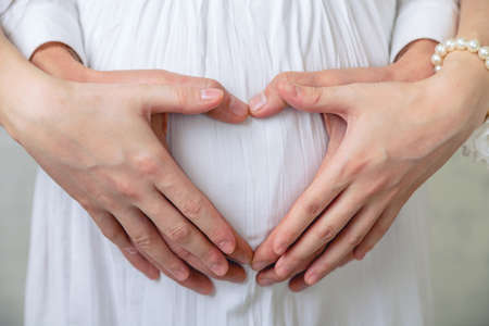 Waiting for baby. Happy couple heart on belly wife