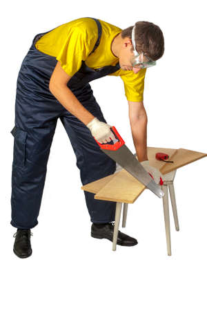 Isolate the man in the yellow shirt in overalls sawing boardの写真素材