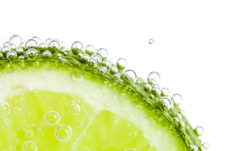 slice of lime in the water with bubblesの写真素材