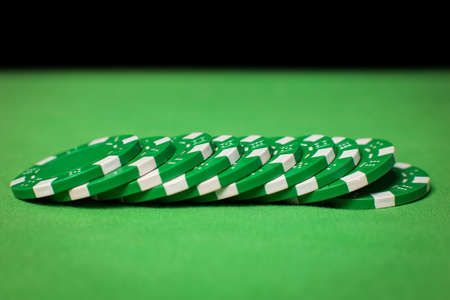 stack of poker chips on a green tableの写真素材
