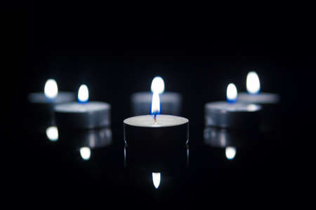 Tea Candles with Reflection on Black background. Cold lightの写真素材