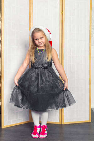 Little girl with white hair in a gray dress red shoes posing standingの写真素材