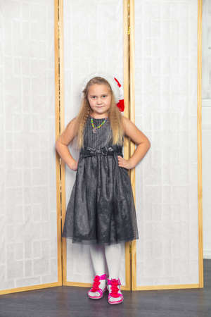 Little girl with white hair in a gray dress red shoes posing standingの写真素材