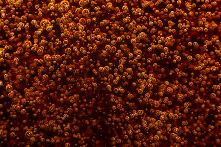 Macro black bubbles on the glass wall of cola rise upの写真素材