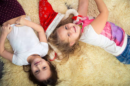 two little girls on the floor, playing at home, top viewの写真素材