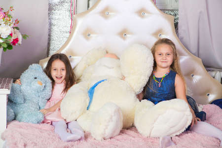 Two little girls in bed with soft toysの写真素材