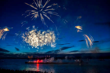 colorful fireworks on the black sky background over-waterの写真素材