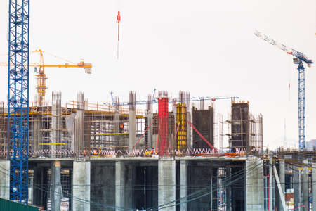 the construction crane and the building against the blue sky